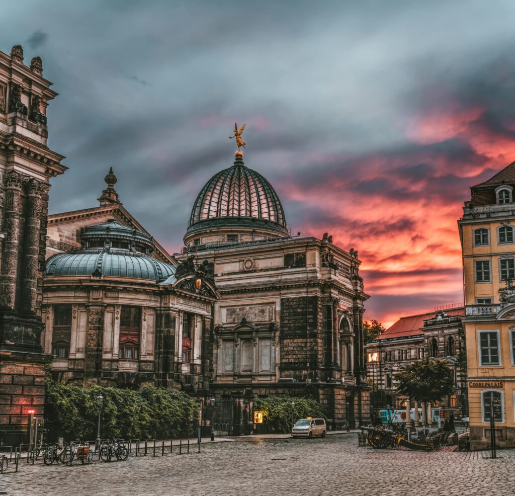 Captivating view of historic domed structures during a stunning sunset, highlighting urban architecture.